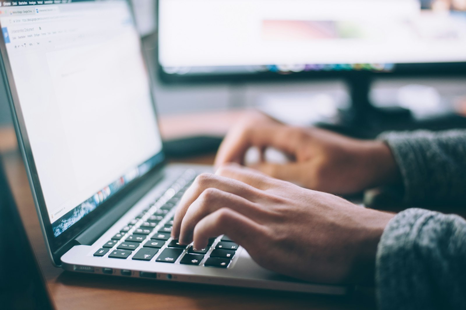 Layered documents and a laptop on a desk, standing in for chat, search and a knowledge layer